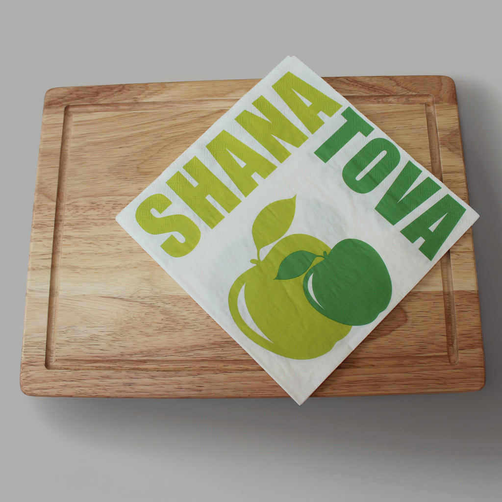 wooden chopping board with green apple serviettes 